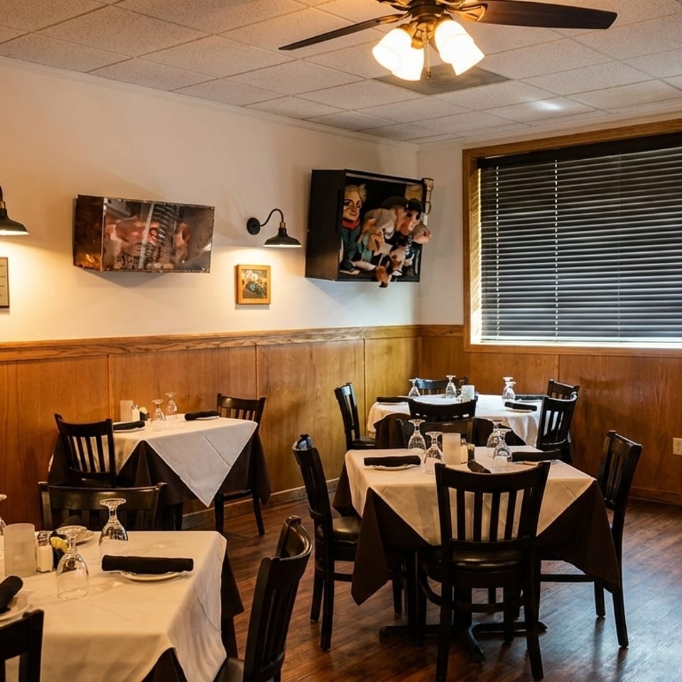 Cozy restaurant dining room with wooden paneling, set tables, and unique wall decor including puppets.